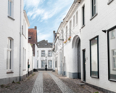 清晨在荷兰Thorn的白漆建筑物空闲老城街上铺有背景图片