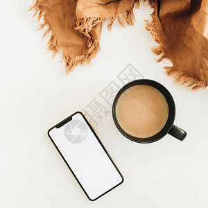 一杯咖啡棕色毯子和智能手机图片