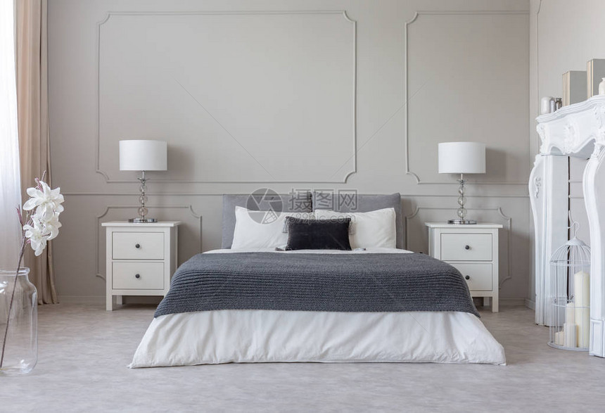 舒适的特大号床上白色床上用品上的灰色毯子图片
