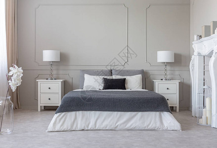 舒适的特大号床上白色床上用品上的灰色毯子图片