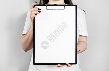 女人拿着剪贴板和一张空白的纸女手中的空白纸海报平面设计师作品图片