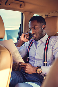 身穿白衬衫的非洲男子通过智能手机交谈图片
