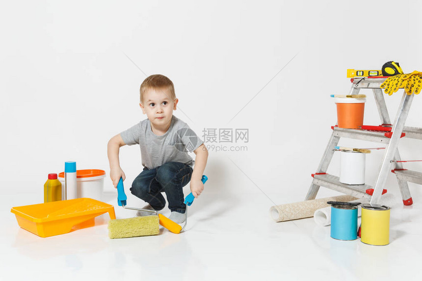 可爱的小男孩站在白色背景上孤立的翻新公寓房间的仪器壁纸胶合配件绘画工具儿子修理家为人父图片