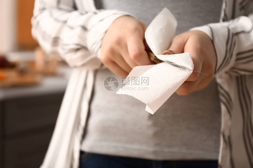 女人在用纸巾擦刀特写图片