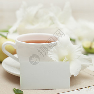 白色纸唐菖蒲花和茶杯背景图片