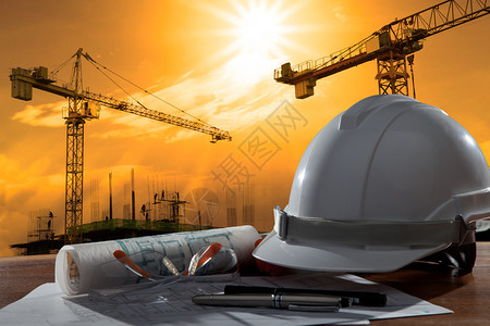 安全头盔和建筑师在日落场景和建筑施工的木图片