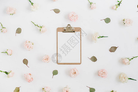 白色背景上带剪贴板的平面花卉框架米色玫瑰花蕾图案顶级视图片