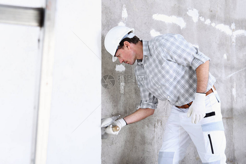 用抹子灰室内建筑工地墙壁的泥水匠人戴头图片