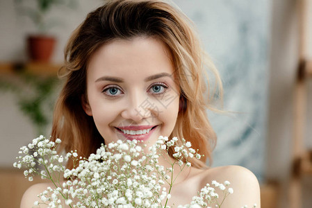 美丽的年轻女子的肖像她拿着白色鲜花图片