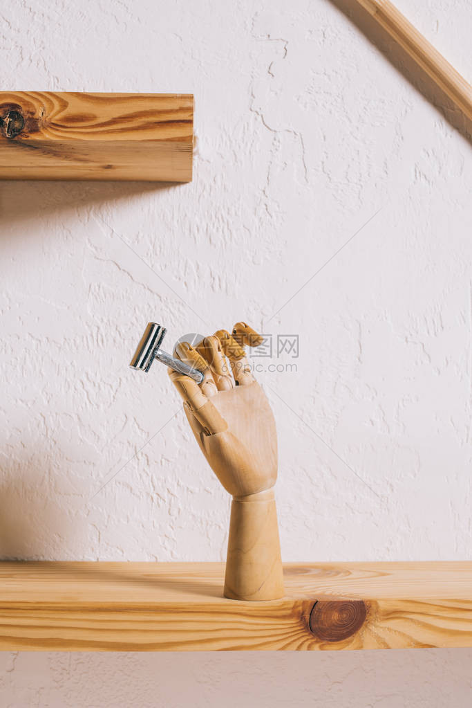 架子上带刀片的装饰木手的特写视图图片