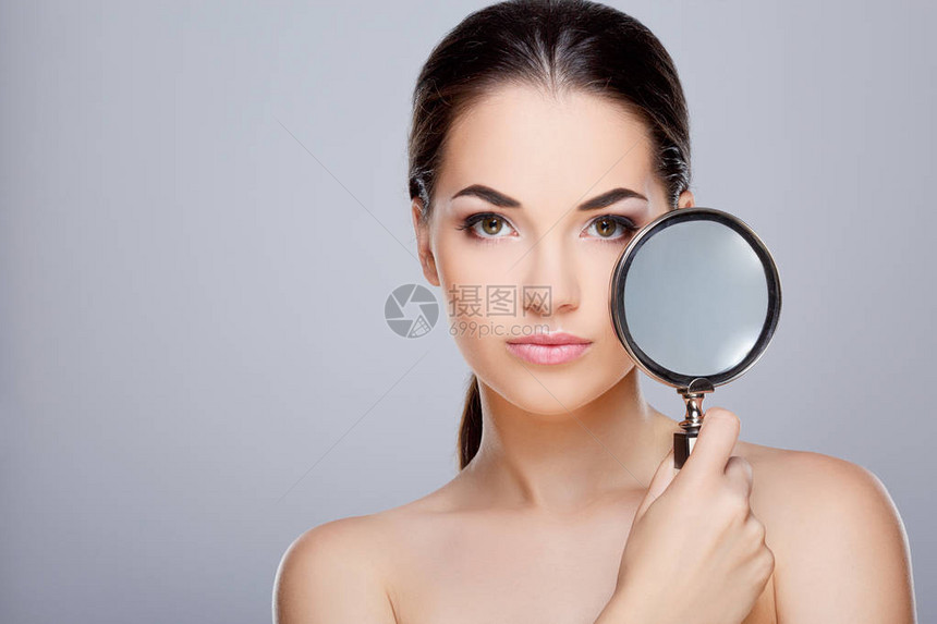 完美化妆的女孩的美丽肖像美丽的女孩拿着镜子看着相机图片