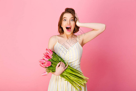 兴奋的女人的肖像与粉红色的郁金香花束图片