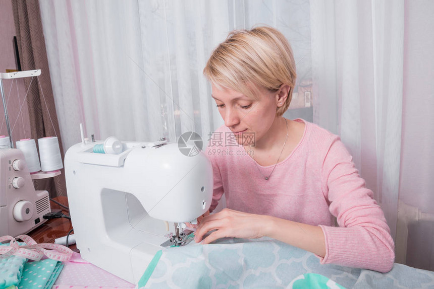 美丽的女裁缝在纫机上缝衣服缝纫车间图片
