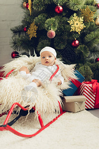 穿着雪橇的可爱小宝在圣诞图片