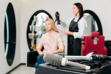 理发师用前台的圆毛刷吹干顾客的头发图片