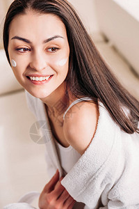 穿着白浴袍的年轻微笑的女人脸图片
