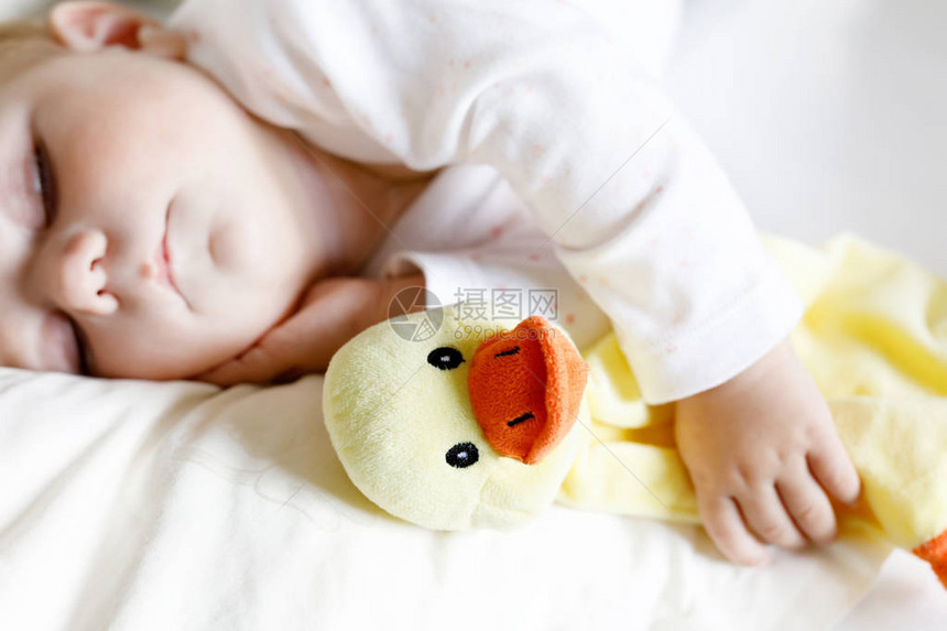 个月大的可爱女婴在家里安静地睡在床上拿着毛绒玩具鸭子的孩子美丽的孩子图片