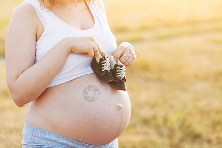 9个月的孕妇在肚子上穿着婴儿鞋怀孕9个图片