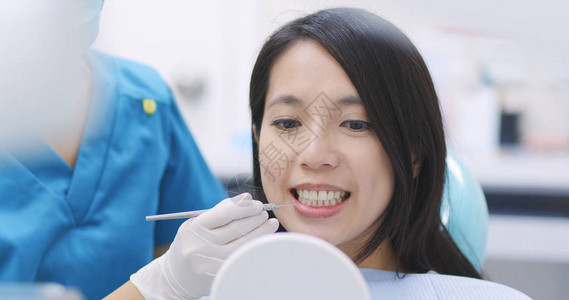 在牙科检查牙齿的女人图片