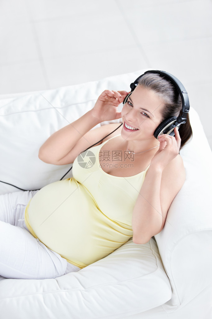 沙发上戴耳机的孕妇图片
