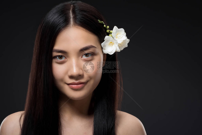 美丽的微笑着的亚洲女人的肖像白花在头发图片
