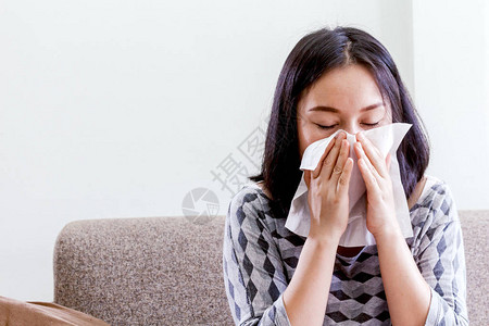 生病的女人用纸巾擤鼻涕图片