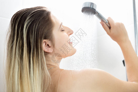 在淋浴时洗长发的年轻女子的肖像图片