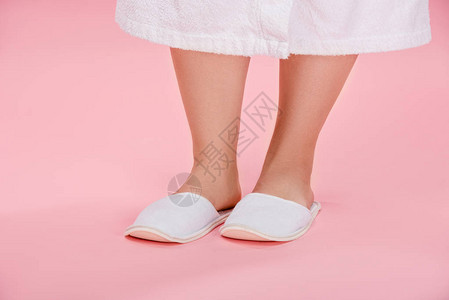 身穿白色拖鞋和浴袍站在粉红色上的年轻超图片