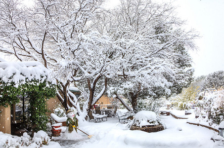 雪暴过后在庭院的雪人和有雪的覆图片