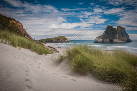 在新西兰南部岛屿FamousWharariki海滩的沙丘和草种植物村图片