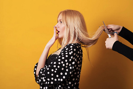 长发的金发美女做发型剪刀图片