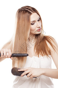 红发女孩用直发器拉直头发背景图片