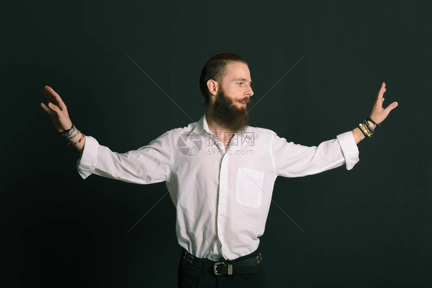 黑背景在工作室穿白衬衫的长胡子男图片