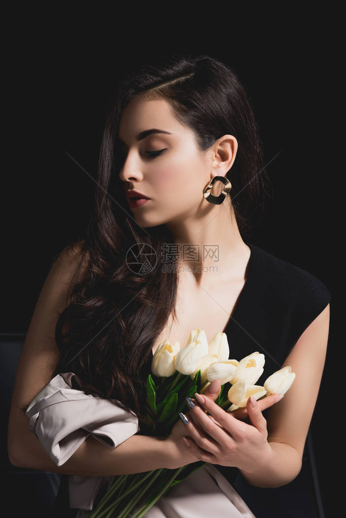 妇女穿着优雅的裙子坐着和拿着花束与黑色图片