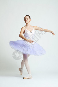 一位年轻漂亮的芭蕾舞者在白种背景下练舞图片