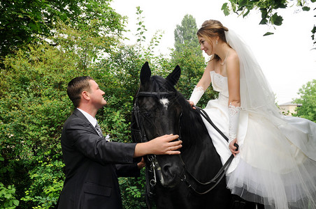 美丽的婚礼新娘和新郎在马背上图片
