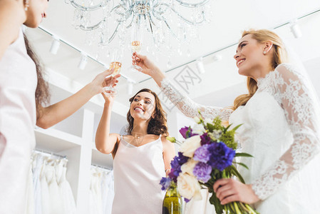 在婚礼服上微笑的女人和在婚礼沙龙里喝背景图片