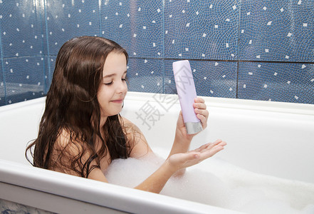用洗发水洗澡的棕色长发小女孩图片