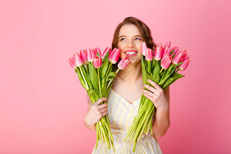 快乐女人的肖像用粉红春郁金香的花束图片