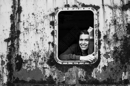 在车窗旧列车上的年轻快乐女图片