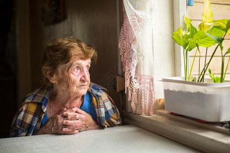 忧郁的老妇人望着窗外图片