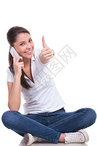 在电话上说话的随意青年妇女举起大拇指手势图片