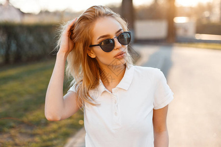 现代时尚的年轻时髦女人穿着时髦的白色马球t恤图片