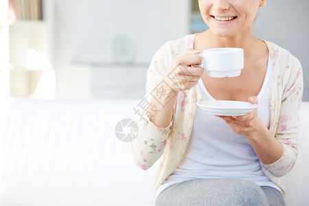 年轻微笑的女人喝茶的形象图片