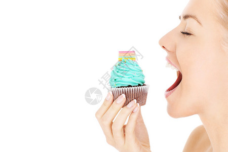 一张年轻快乐的女子在白色背景上吃蛋糕的照图片