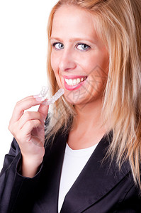 将牙齿美白托盘插入嘴里的女人图片