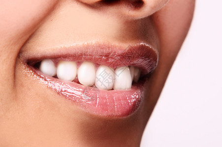 微笑的女人嘴里长着大牙齿在白色背景图片
