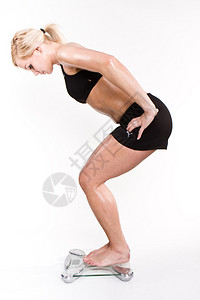 体重秤上的金发健身女人图片
