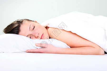 一张美丽的年轻女子在白色背景中睡觉的照图片