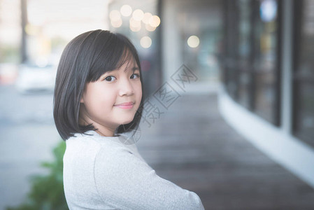 美丽的亚洲女孩站在户外与城市对图片